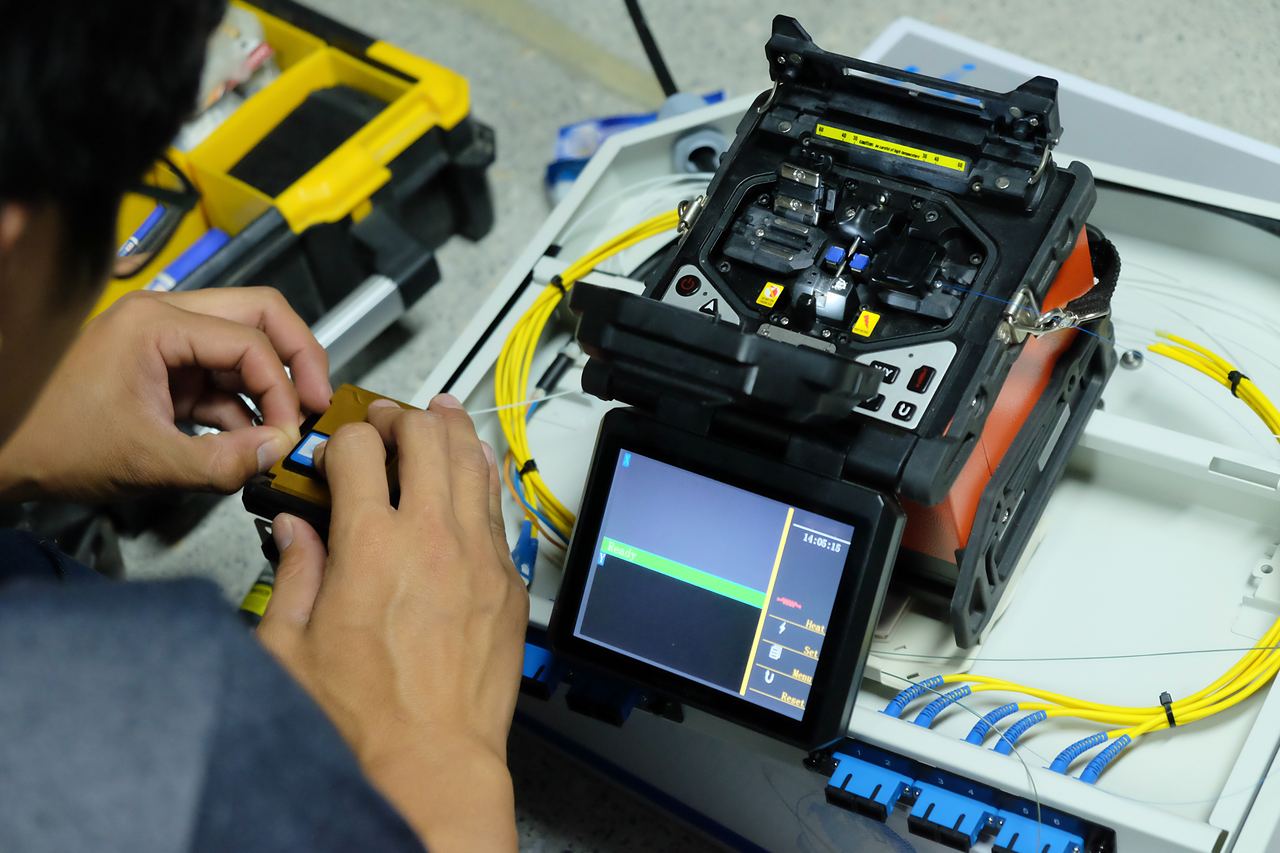 Technician preparing fibre on a fusion splicer