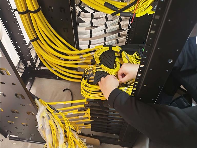 Technician dressing fibre cables in a rack