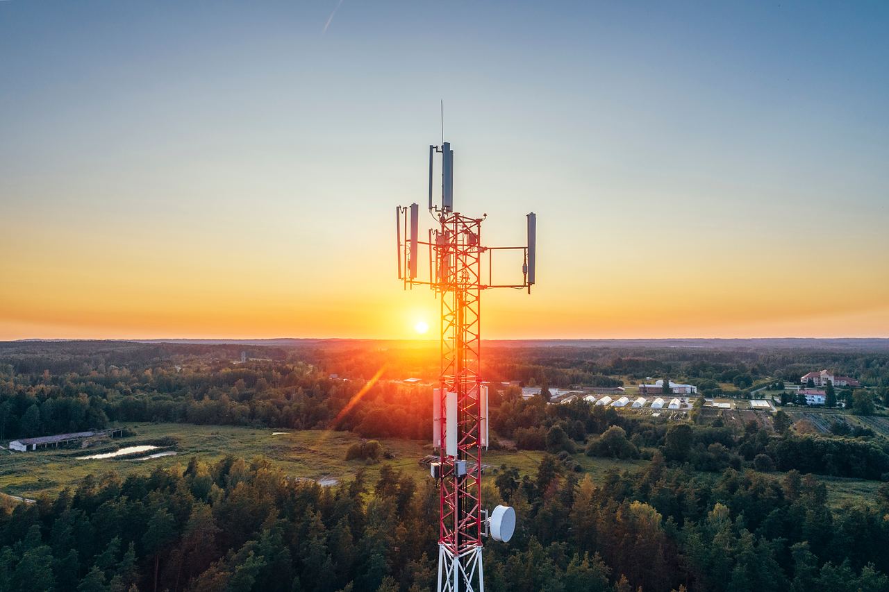 Telecommunication tower against a sunset, seen from the air