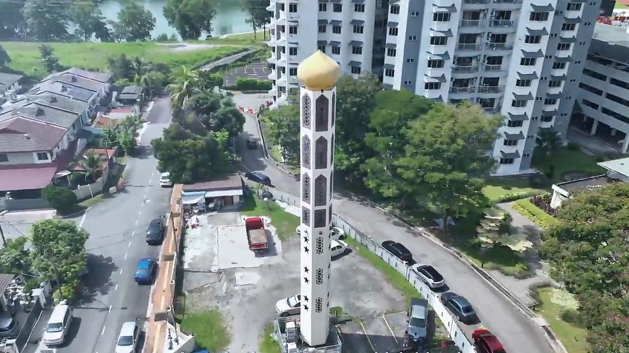Aerial view of a minaret-style telecommunication structure beside a residential neighbourhood in Malaysia