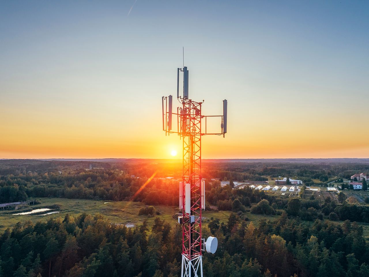 Telecommunication tower against a sunset, seen from the air
